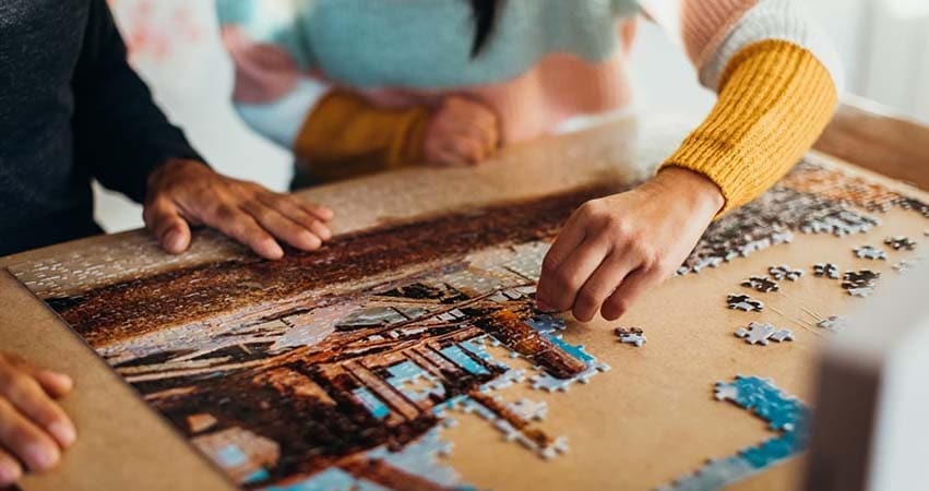 puzzle géant mini pièces 2 mains sur une table bureau