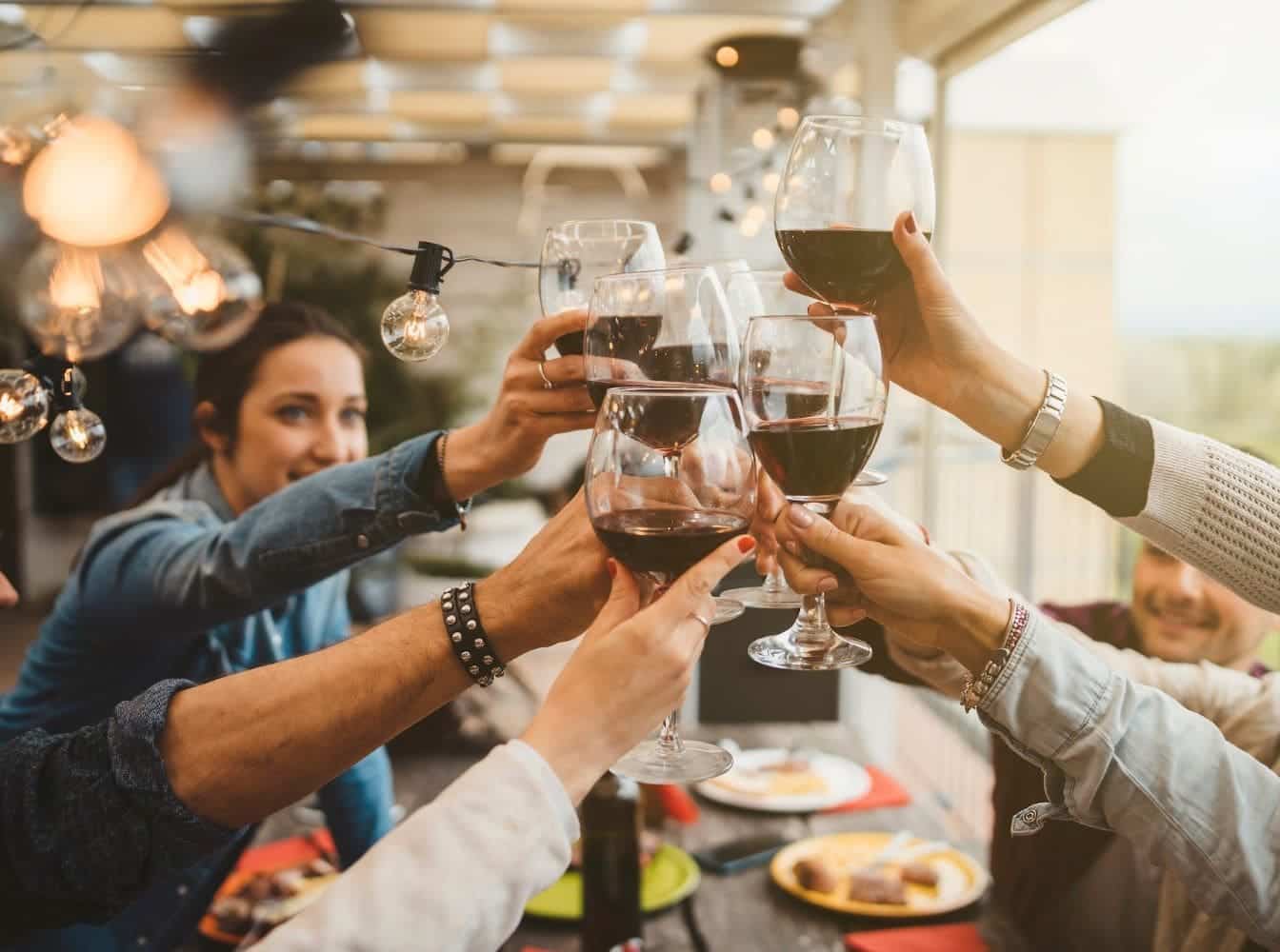 dégustation vin rouge verre levé entre amis autour d'une table