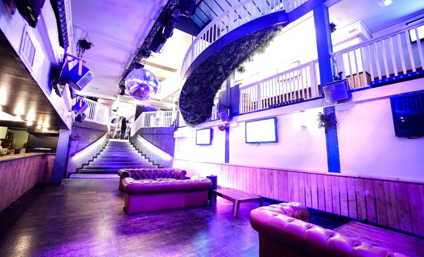 salle privatisée anniversaire canapé chesterfield marron cuir lumiere violette parquet bar