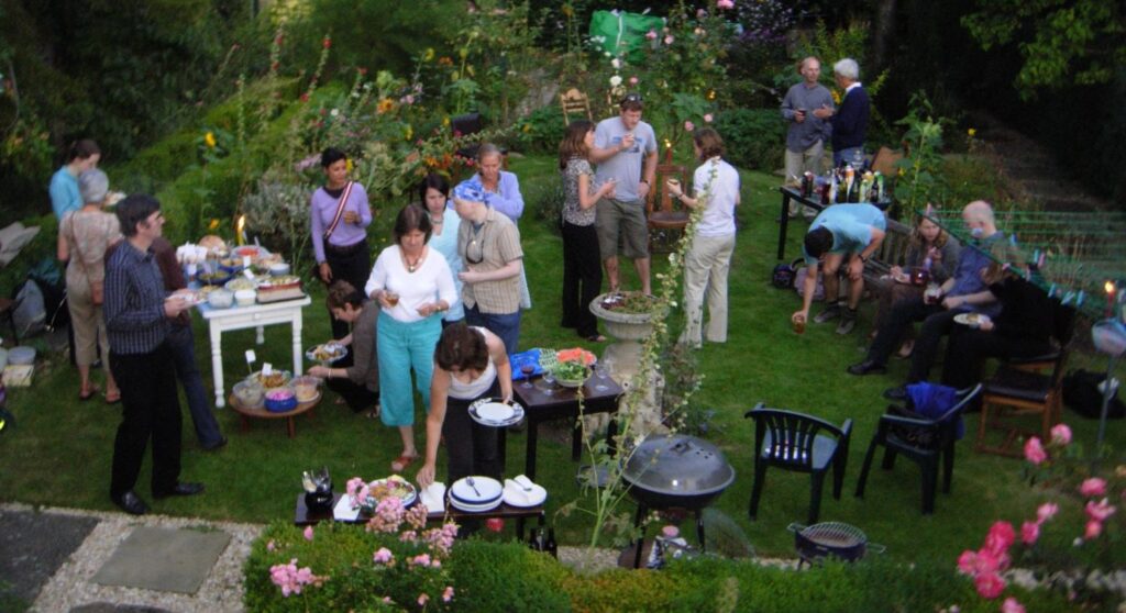 garden party dans le jardin à lam aison plein de monde barbecue fin de journée