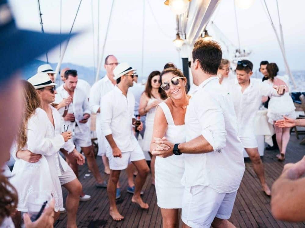 soiréee blanche sur un bateau personne dansant sur le pont voilier dress code tenue short chemise blanc