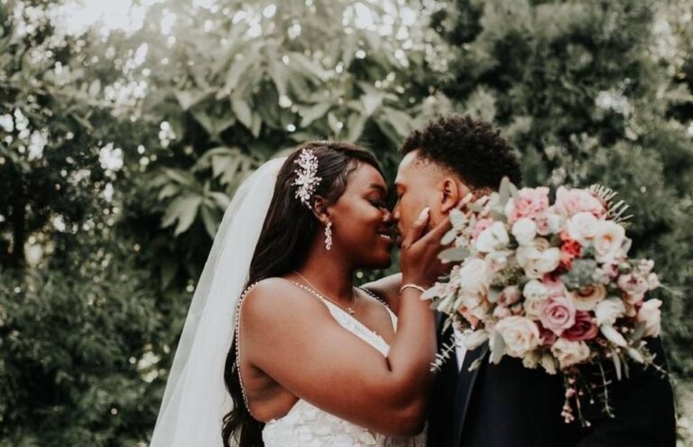 couple afro mariés heureux baiser mariage bouquet de fleurs végétation extérieure