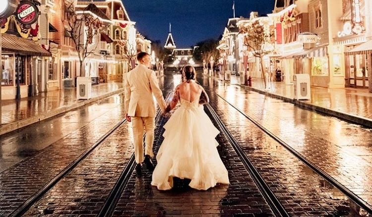 photo des mariés de dos sur main street disneyland rails nuit robe costume blanc