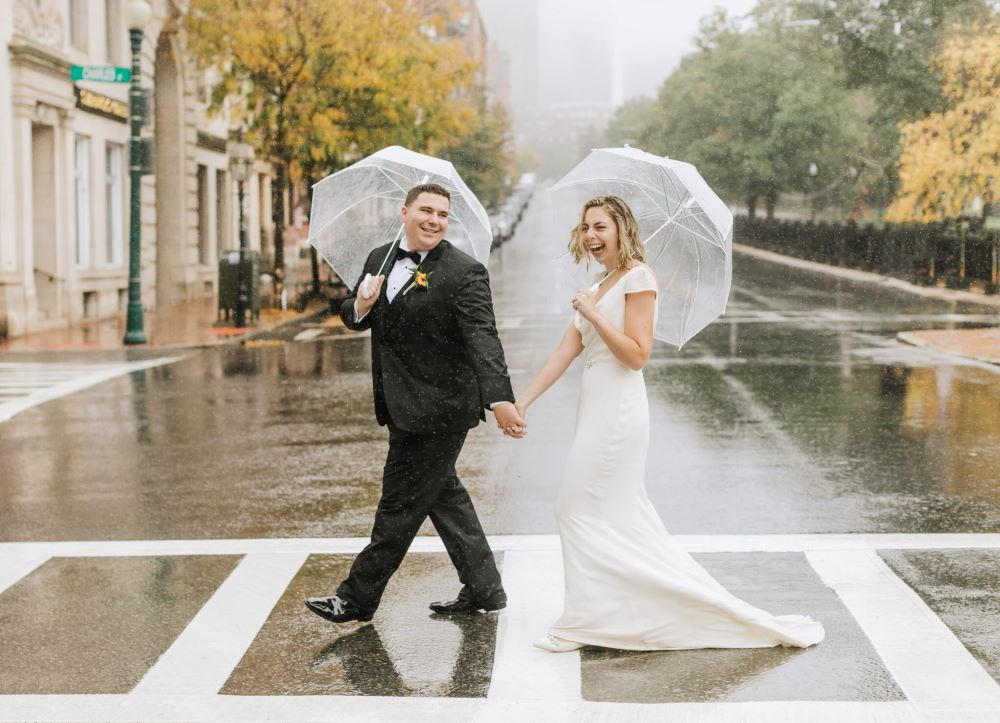 mariage pluvieux couple homme femme robe marié parapluie traverser la rue mouillée mariés heureux