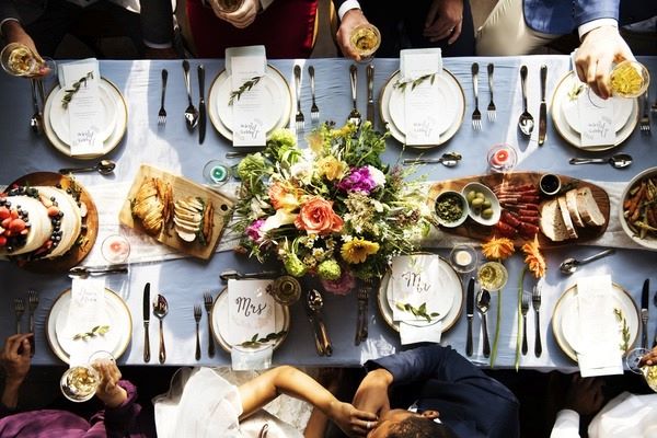 table de repas de mariage vue du haut assiettes bouquet et invités