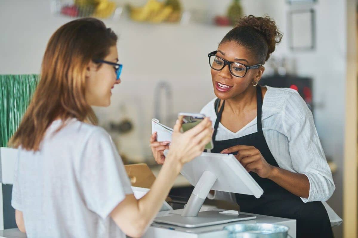 commerçant qui regarde smartphone client compte fidélité achat