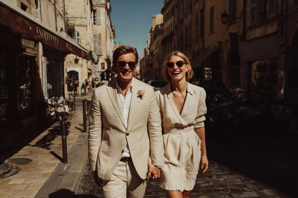 Couple de mariés sortant de la mairie en semaine dans une rue calme et ensoleillée