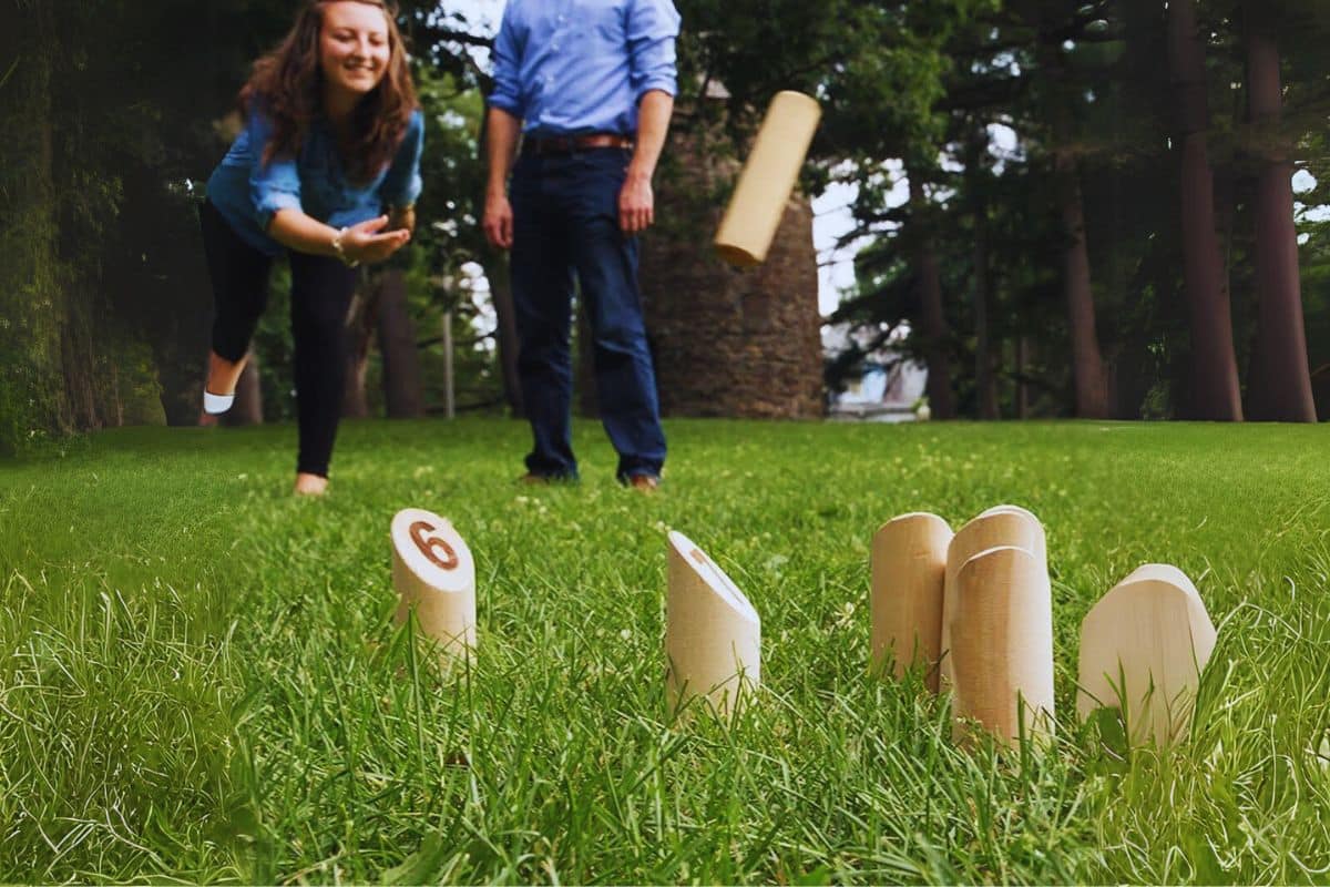invités mariage jouent au jeu du molkky jardin herbe adresse lancé
