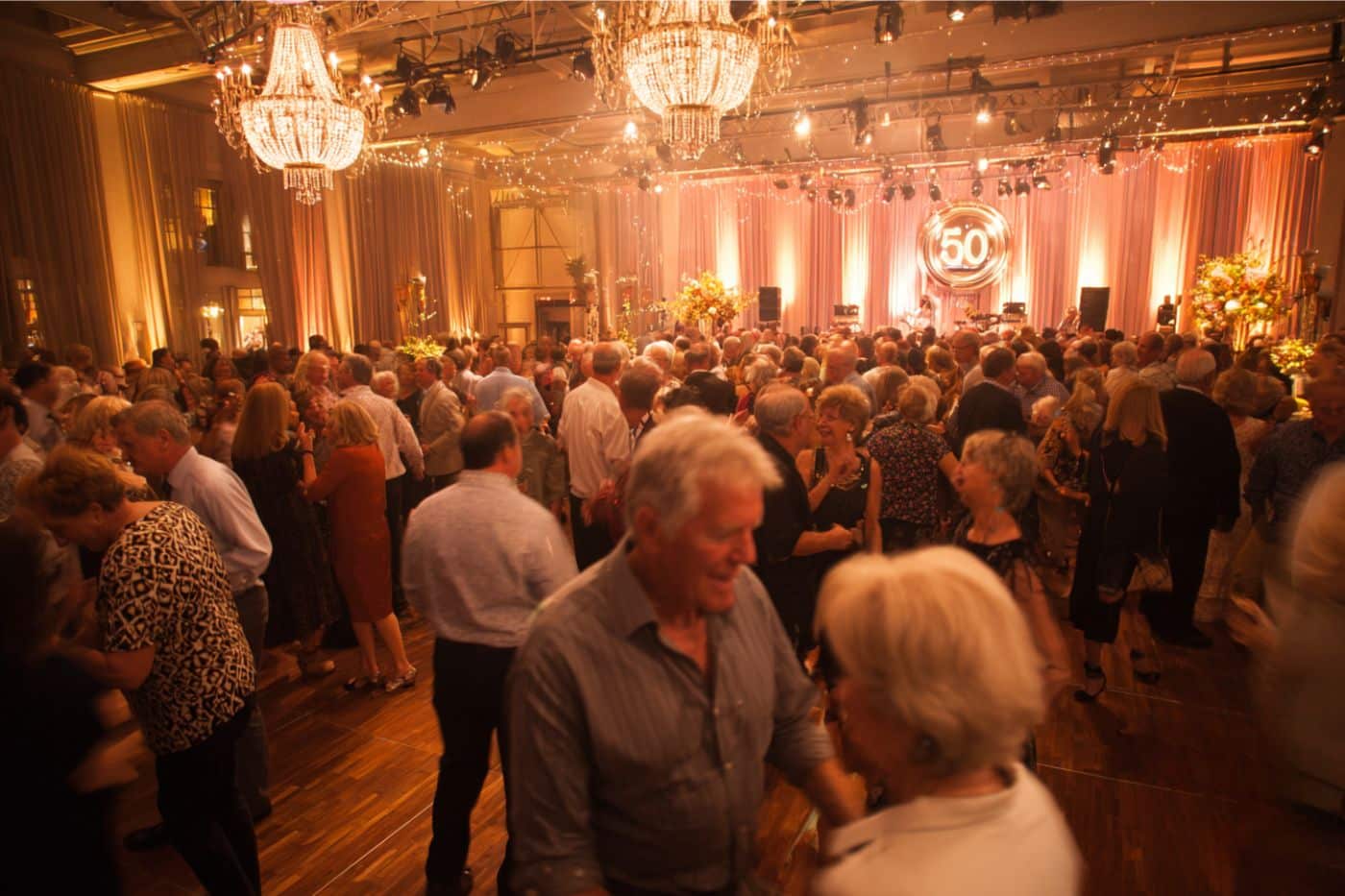 Soirée dansante élégante pour anniversaire 50 ans avec invités en tenue chic sur piste illuminée
