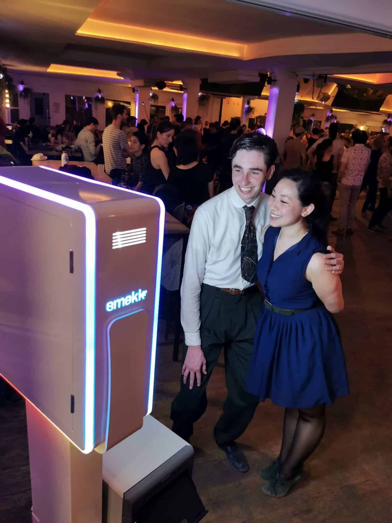 Couple posant devant la borne photobooth Smakk pendant une soirée dansante dans une grande salle