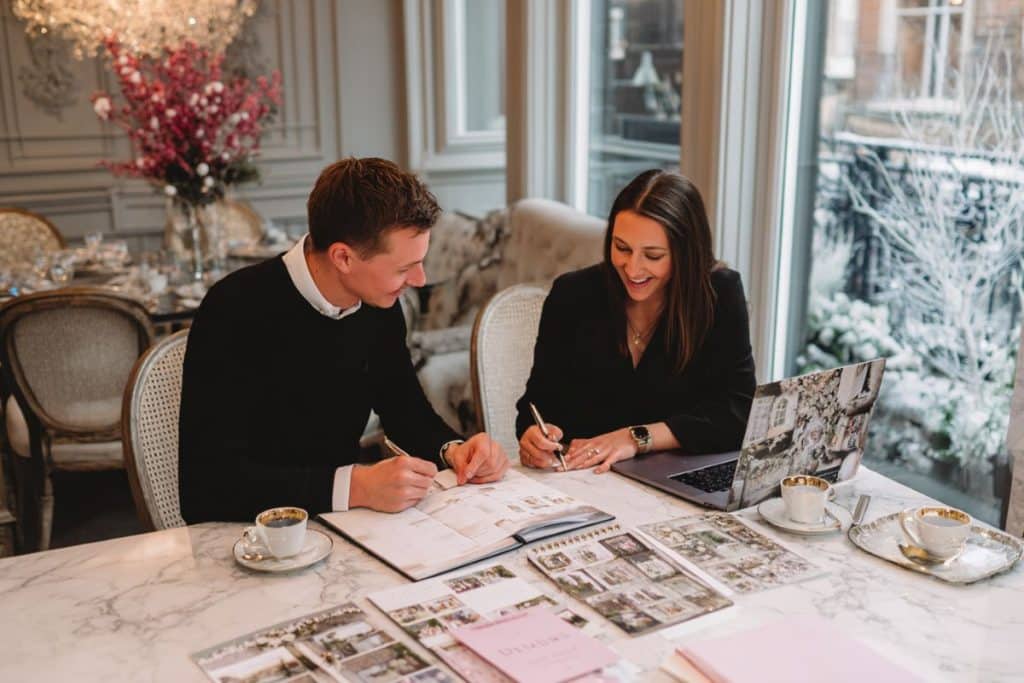 Couple rencontrant leur wedding planner pour organiser et réserver les prestataires de leur mariage d'hiver