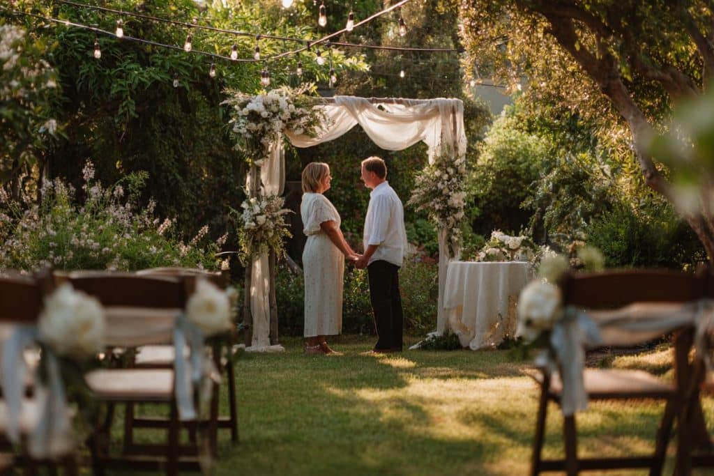 Renouvellement des vœux dans un jardin intimiste avec un couple mature sous des guirlandes lumineuses
