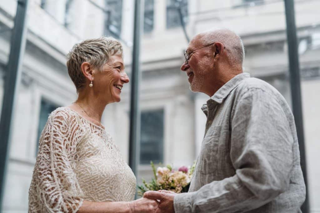 Couple senior célébrant leur renouvellement de vœux à la mairie entourés de leurs proches