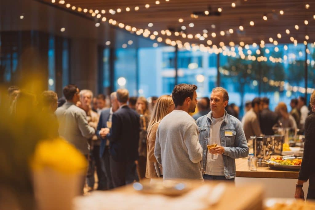 Soirée d’entreprise moderne avec collaborateurs qui discutent et participent à des animations dans un espace événementiel convivial