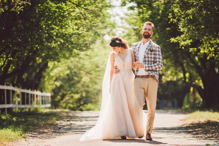photographie des mariés campagne extérieur couple se tiennent par le bras