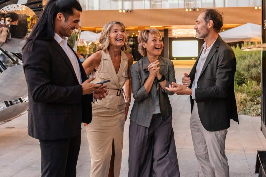 dialogue entre collègue événement corporate hommes et femmes rigolent en extérieur