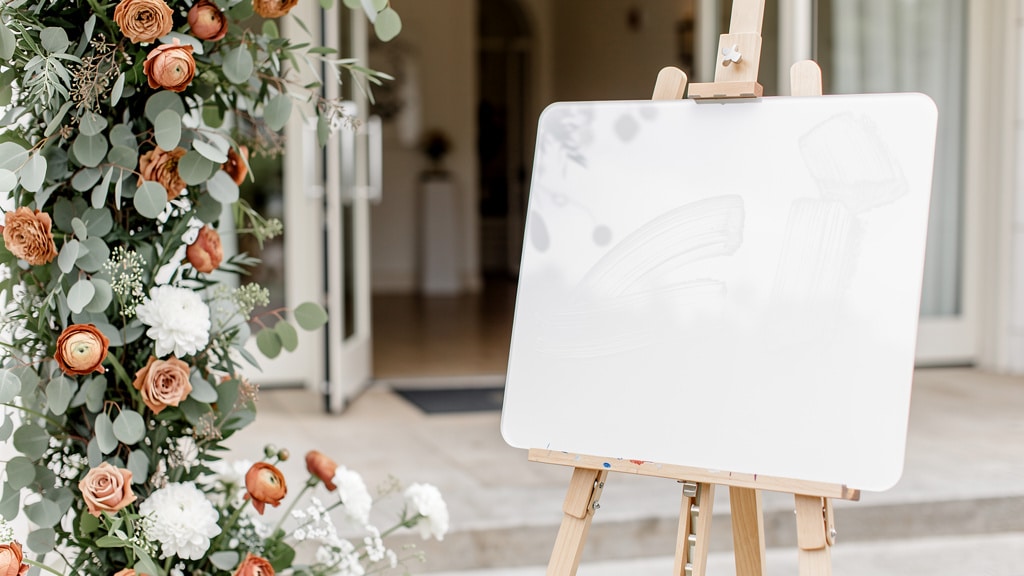 Panneau de bienvenue mariage sur chevalet à l'entrée d'un lieu de réception