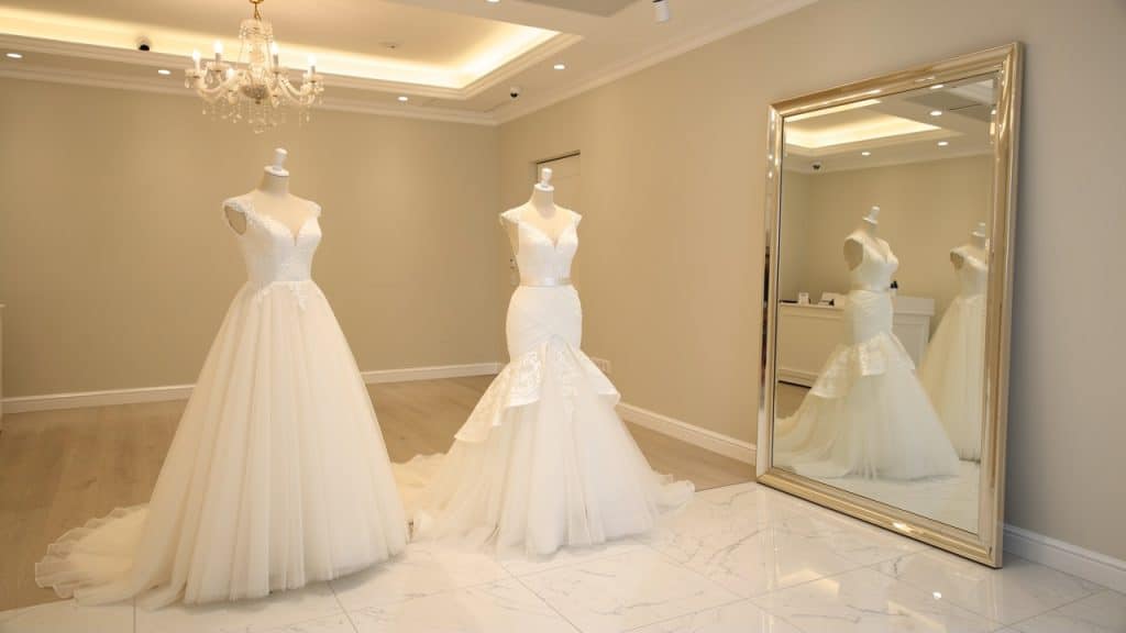 Deux coupes de robes de mariée (princesse et sirène) présentées sur mannequins dans une boutique
