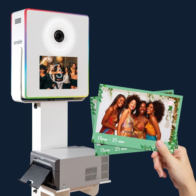 Photobooth Smakk blanc avec imprimante intégrée et tirages photo 10x15 tenus en main