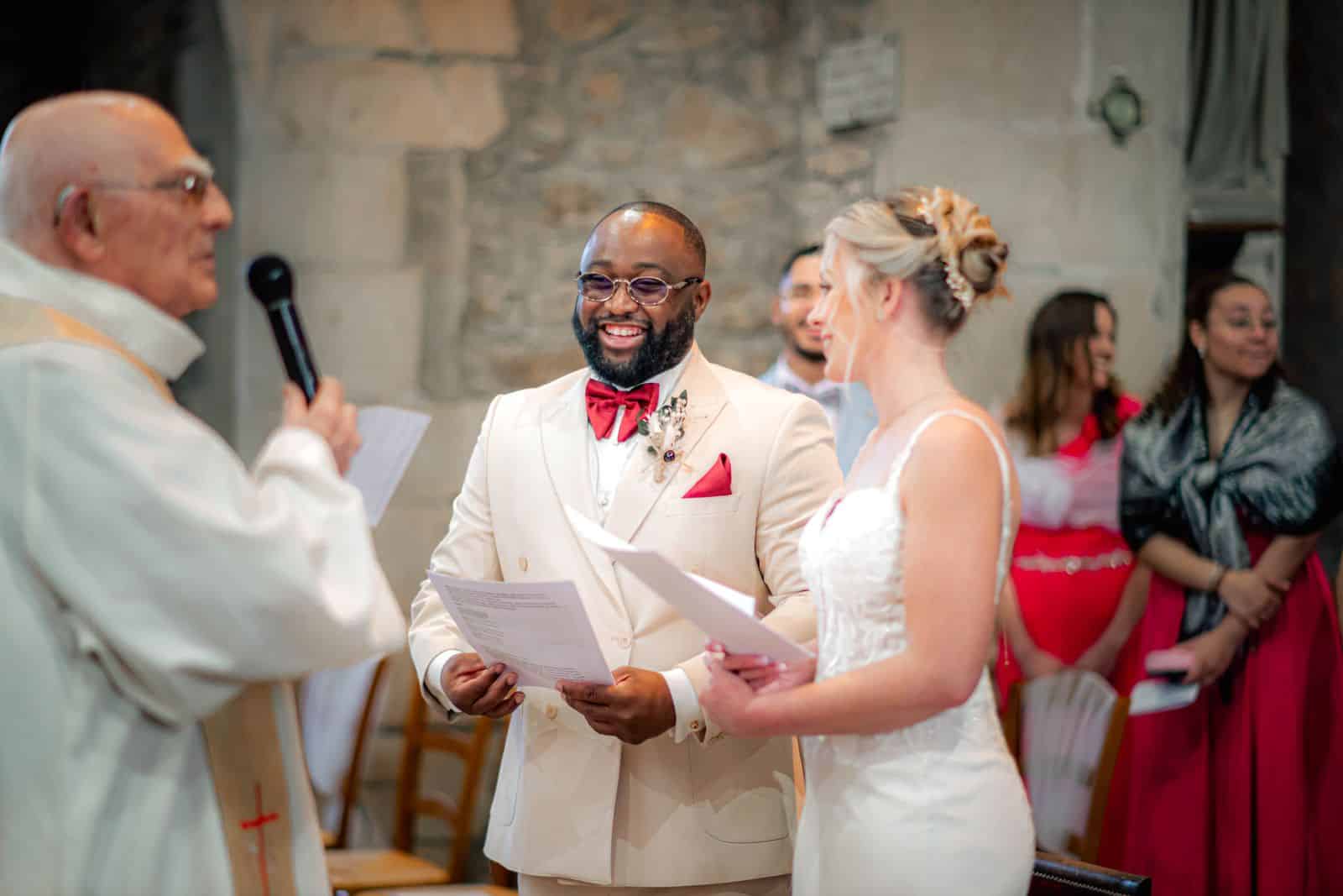Mariage à l'étranger : couple qui échange ses vœux devant l'officiant dans une église en pierre